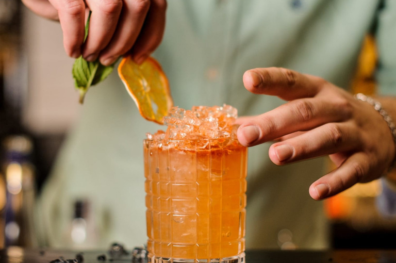 Bartender adding garnish to a cocktail